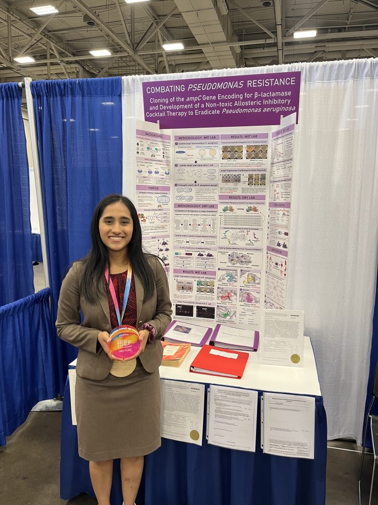 Shriya Bhat standing in front of her winning poster and wearing her medal at an ISEF competition